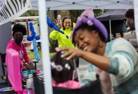  ?? Edward Linsmier, © The New York Times ?? Renee Edwards waves to a child at a face-painting booth at the Saturday Morning Shoppe, a monthly outdoor market she started, in St. Petersburg, Fla., on Nov. 6.