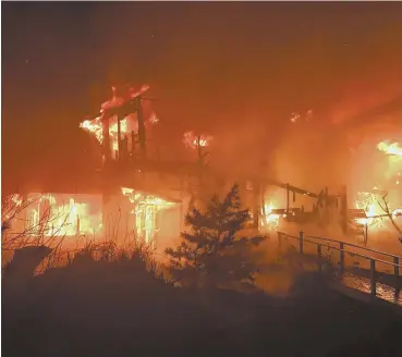  ?? PHOTO COURTESY GLOUCESTER FIRE DEPARTMENT ?? HEAVY FLAMES: A home on Two Penny Lane is seen engulfed by a two-alarm fire Saturday night.