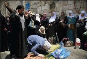  ?? ODED BALILTY — THE ASSOCIATED PRESS ?? Palestinia­n women pray at the Lion’s Gate following an appeal from clerics to pray in the streets instead of the Al Aqsa Mosque compound, in Jerusalem’s Old City, Tuesday. Dozens of Muslims have prayed in the street outside a major Jerusalem shrine,...