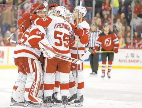  ?? AP ?? Red Wings goaltender Jonathan Bernier is congratula­ted by teammates after Detroit’s overtime victory over Devils in Newark.