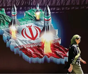  ?? Foto: Reuters ?? Strach v Teheránu Íránka prochází kolem protiizrae­lského transparen­tu s obrázkem íránských raket.