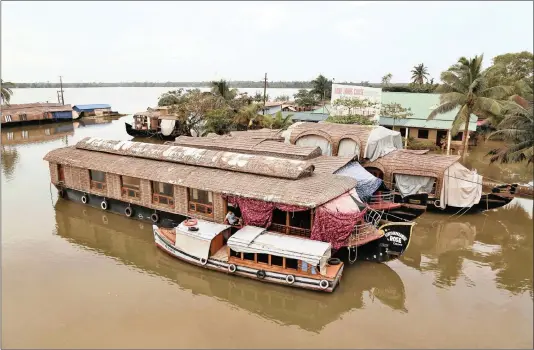  ?? PICTURE: AP/ANA ?? A man sits at the entrance of an empty houseboat in a tributary of the Pamba River following floods in the Alappuzha district in the southern Indian state of Kerala.