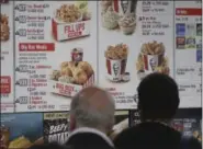  ?? AP PHOTO/BEBETO MATTHEWS ?? In this Aug. 24 photo, customers look over a KFC menu labeled with calorie counts, in New York.