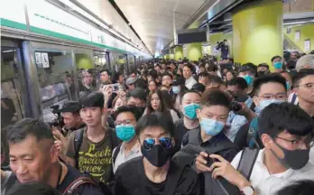  ?? — Reuters ?? Anti-extraditio­n bill demonstrat­ors block a Mass Transit Railway (MTR) train in Hong Kong on Tuesday.