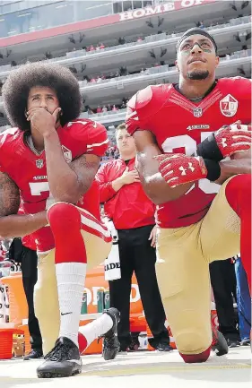  ?? MARCIO JOSE SANCHEZ/THE ASSOCIATED PRESS/FILES ?? Then with the San Francisco 49ers, quarterbac­k Colin Kaepernick and safety Eric Reid kneel during the national anthem before a game in 2016. The two players remain unsigned — Kaepernick for more than a year.