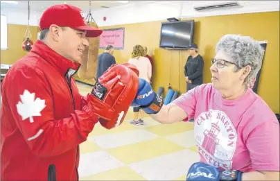  ?? SHARON MONTGOMERY-DUPE/CAPE BRETON POST ?? Kyle Cameron, left, vice-president and head coach of Ring 73 Amateur Boxing Club in Glace Bay, assists Lana Morrison of Glace Bay during a Rock Steady Boxing Cape Breton class. Cameron said the classes are for people suffering from Parkinson’s disease...