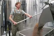  ?? AP PHOTO/AMANDA LOMAN ?? Brewer Scott Peterson retrieves spent grain from a lauterton Oct. 22 while brewing a German-style Pilsner at Von Ebert Brewing in Portland, Ore.