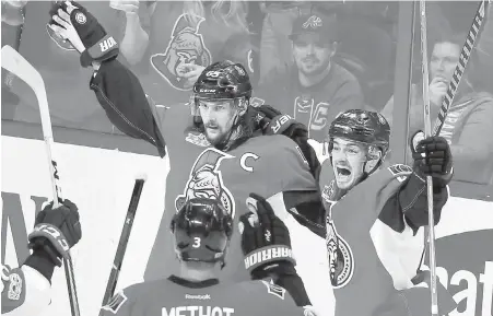  ??  ?? Senators captain Erik Karlsson celebrates his goal against the Rangers with teammates centre Jean-Gabriel Pageau and Marc Methot during the third period of Game 1 in Ottawa on Thursday.