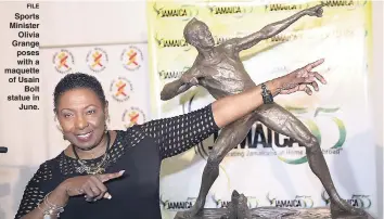  ?? FILE ?? Sports Minister Olivia Grange poses with a maquette of Usain Bolt statue in June.