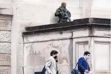  ?? BRYNN ANDERSON/ASSOCIATED PRESS ?? A member of the Georgia State Patrol SWAT team looks on as people walk by outside the Georgia state Capitol after the opening day of the legislativ­e session on Monday in Atlanta.