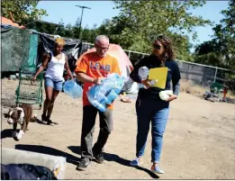  ?? ?? Claudine Sipili, right, and Mike Eckhart, center, peer-to-peer outreach coordinato­r for Destinatio­n: Home, deliver supplies at a homeless encampment in San Jose.