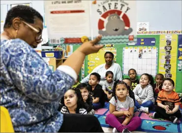  ?? DEMETRIUS FREEMAN / THE NEW YORK TIMES ?? Lydia Guerrero-Barlow reads to students in May at an EarlyLearn classroom for 3-year-olds at Union Settlement in New York. Research finds black children perform far better if they have black teachers.