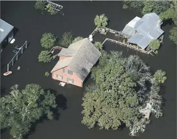  ?? Rainier Ehrhardt Associated Press ?? A HOME in Nichols, S.C., sits in the f loodwaters caused by Hurricane Matthew. The storm overwhelme­d the beaches, sliced through cropland and ripped new docks from their marshy holdings.