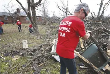  ?? George Walker IV/The Tennessean via AP ?? Russ Freeman of Donelson Fellowship church disaster response team works to clean up tornado debris along McGavock Pike on Wednesday in Nashville, Tenn.