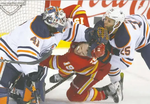  ?? JIM WELLS ?? Oilers goalie Mike Smith and Darnell Nurse rough up Flames forward Matthew Tkachuk during NHL action at the Scotiabank Saddledome in Calgary on March 26. For the first time since 1991, the Battle of Alberta will resume under playoff conditions as the provincial rivals square off in a best-of-seven second-round series beginning Wednesday night in Calgary.