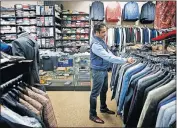  ?? OKLAHOMAN] [BRYAN TERRY/ THE ?? Andy Mahbubani, owner of GQ Fashions Fine Menswear, looks over inventory inside the store Thursday in preparatio­n for its opening Saturday.