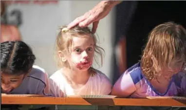  ?? PETE BANNAN — DIGITAL FIRST MEDIA ?? Ana Saritsoglo­u, 6, of Newtown Square, center, took home the $5 prize in the pie-eating contest for girls 8 and under at the Goshen Country Fair. The contest will run throughout the week.