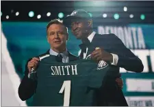  ?? BY TONY DEJACK - THE ASSOCIATED PRESS ?? Alabama wide receiver DeVonta Smith, right, holds up an Eagles team jersey with the steady hand help of NFL Commission­er Roger Goodell Thursday night. The Eagles traded up to No. 10 in the draft to select Smith.