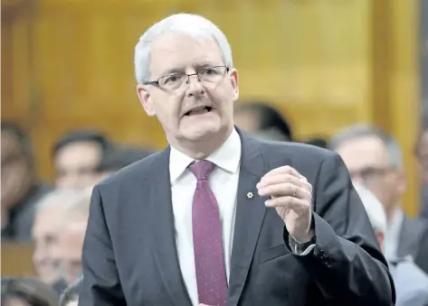  ?? THE CANADIAN PRESS FILES ?? Transport Minister Marc Garneau responds to a question during question period in the House of Commons on Parliament Hill in Ottawa in June. Documents show Transport Canada went ahead with building a $5.4-million crash barrier at one of its vehicle test...