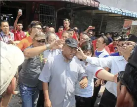  ??  ?? rowdy crowd: Johor PAS complaints bureau head Syed othman Abdullah (in cap) being slapped while escorting lim out of the coffee shop in Taman Megah Ria, Seri Alam, Johor.