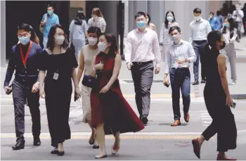  ?? — Reuters ?? Office workers spend their lunch breaks at the central business district in Singapore.
