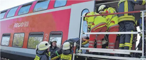  ?? FOTOS: ANGELIKA GRETZINGER ?? Über Podeste wurden die verletzten Zugreisend­en bei der Übung aus den Waggons geholt.