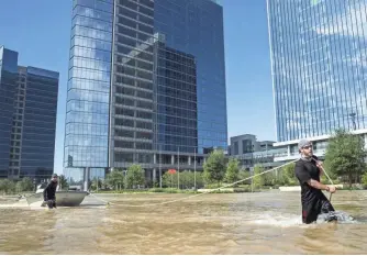  ?? ERICH SCHLEGEL, GETTY IMAGES ?? Rescuers from Odessa, Texas, make their way through floodwater­s along Eldridge Parkway in the Energy Corridor of west Houston on Wednesday.