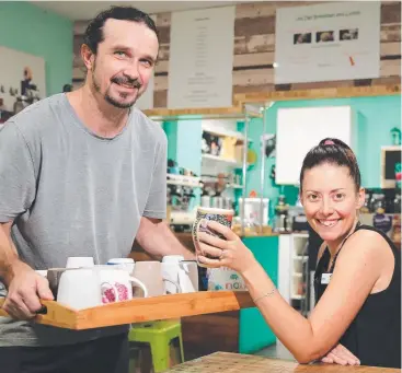  ?? Picture: JUSTIN BRIERTY ?? GUILT FREE: Cairns Square’s Shop 3 owner Chris Adermann offers a recycled ceramic cup to customer Sophie Anderson, who helped initiate the idea.