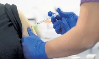  ?? CHARLES REX ARBOGAST / AP ?? A nurse at Saint Anthony Hospital administer­s the first of the two Pfizer-BioNTech COVID-19 vaccinatio­ns to a hospital worker at the facility in Chicago on Wednesday.