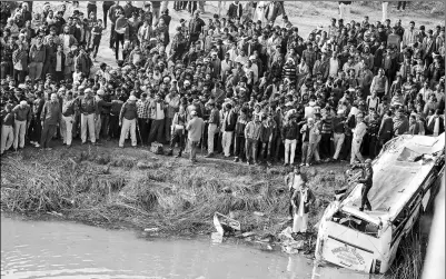  ?? PROVIDED BY XINHUA ?? People gather at the site after at least 33 were killed on Saturday after a passenger bus veered off a bridge and plunged into a river in Rajasthan, India. The vehicle plunged 20 meters into the Banas River. Police figures show India has the world’s highest road accident death toll, with more than 110,000 people dying each year in crashes.