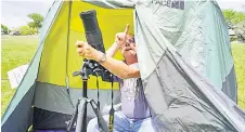  ?? ?? A camper at Stonehenge II practices with his camera equipment ahead of Monday’s total solar eclipse.