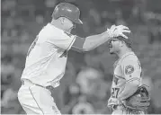  ?? Jayne Kamin-Oncea / Getty Images ?? The Angels’ Mike Trout has a little fun with Astros second baseman Jose Altuve after Trout doubled in the seventh inning.