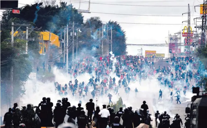  ?? AP ?? Soldados y policías lanzaron gases lacrimógen­os contra los manifestan­tes que protestaro­n contra la investidur­a presidenci­al de Juan Orlando Hernández, en Tegucigalp­a.