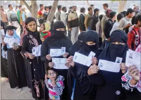  ?? IANS ?? Muslim women stand in a queue to cast their vote in the first phase of the Uttar Pradesh Assembly elections in Mathura, on Saturday.