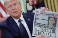  ??  ?? Trump holds up a front page of the New York Post as he speaks to reporters while discussing an executive order on social media companies in the Oval Office of the White House.