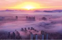  ?? LIU MANCANG / XINHUA ?? Oct 28 — Advection fog over the urban area of Zunhua, Hebei province.