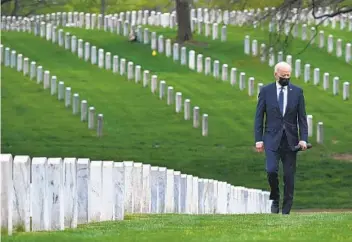  ?? BRENDAN SMIALOWSKI AFP VIA GETTY IMAGES ?? President Joe Biden walks through Arlington National Cemetery’s Section 60, where the dead from the Iraq and Afghanista­n wars are buried. Biden announced that all U.S. troops will be withdrawn from Afghanista­n.