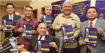  ??  ?? MOHAMED Nazri (duduk, tengah) menunjukka­n poster Anugerah Pelanconga­n Malaysia.