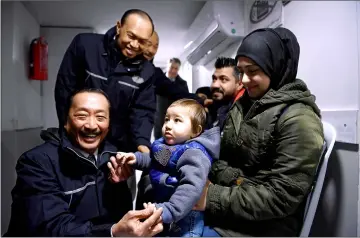  ??  ?? Vincent Tan (front left) and Lim Wee Chai (back left) having a light moment with an 11-month-old Syrian baby Dyjwar Bayram during a visit to a free clinic.