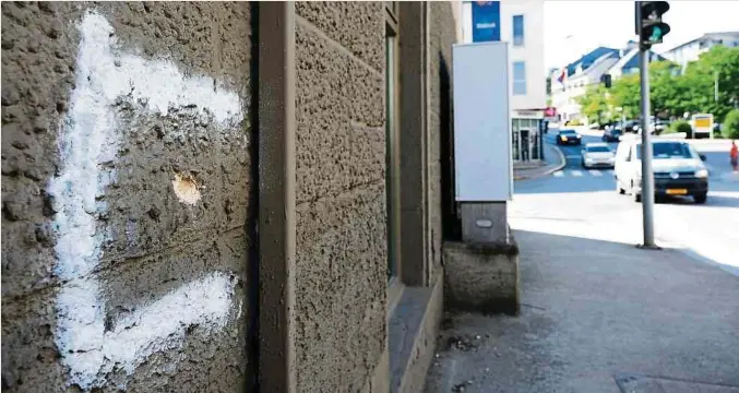  ?? Foto: Fern Morbach/LW-Archiv ?? Drei Kugeln schlagen in der Fassade der Gaststätte in Remich ein, zwischen den Schaufenst­ern und in Kopfhöhe der Menschen im Innern.