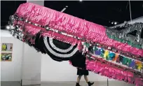  ?? JAE C. HONG/ASSOCIATED PRESS FILE PHOTOS ?? ‘El Rey,’ above, a customized 1963 Chevrolet Impala by Albert de Alba Sr., and ‘Gypsy Rose Piñata,’ left, by Justin Favela are displayed last month during an exhibition titled The High Art of Riding
Low at the Petersen Automotive Museum in Los...