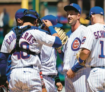  ?? NAM Y. HUH/AP ?? Cubs starting pitcher Drew Smyly, center, listens to pitching coach Tommy Hottovy during the first inning against the Dodgers on Saturday at Wrigley Field.