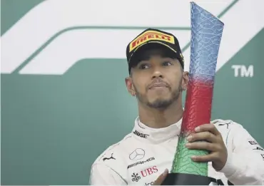  ??  ?? 0 Lewis Hamilton hoists his trophy after his victory in Baku.
PICTURE: CLIVE MASON/ GETTY