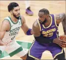  ?? Michael Dwyer / Associated Press ?? Lebron James of the Lakers looks to make a move against Jayson Tatum of the Celtics.