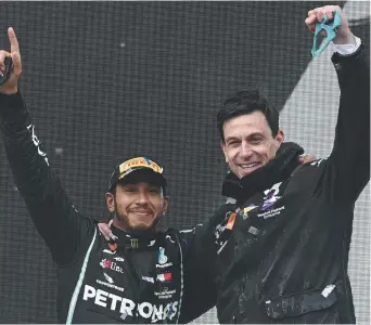  ??  ?? Lewis Hamilton en compagnie du directeur de l’équipe Mercedes, Toto Wolff, à droite, célèbrent après que Hamilton ait remporté le Grand Prix de Turquie de Formule 1 et son septième championna­t du monde, - Associated Press: Ozan Kose/Pool