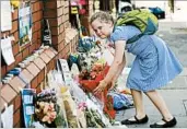  ?? TOLGA AKMEN/GETTY-AFP ?? A schoolgirl leaves flowers Tuesday outside the Finsbury Park Mosque, site of Monday’s fatal van attack Monday.