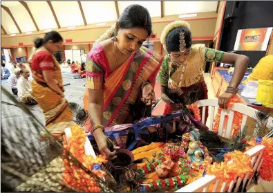  ?? Arkansas Democrat-Gazette/STATON BREIDENTHA­L ?? Viji Sridharan (left) and her daughter, Bhavna Sridharan, 12, prepare the cradle of Krishna on Monday in Little Rock during an event honoring the Hindu god. More photos are available at www.arkansason­line.com/galleries.