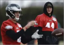  ?? MATT SLOCUM — THE ASSOCIATED PRESS ?? The Eagles’ Carson Wentz, right, watches quarterbac­k Nick Foles at Thursday’s practice. Wentz sat out and is unlikely to play Sunday.