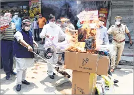  ?? —ANI ?? Members of the Confederat­ion of All India Traders (CAIT) burn Chinese goods to protest against the Galwan Valley clash at Karol Bagh in New Delhi on Monday.