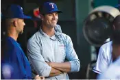  ?? Ashley Landis/ The Dallas Morning News via AP ?? ■ Texas Rangers pitcher Cole Hamels smiles as he talks to teammates in the dugout during the third inning of the team’s baseball game against the Oakland Athletics on Thursday in Arlington, Texas.